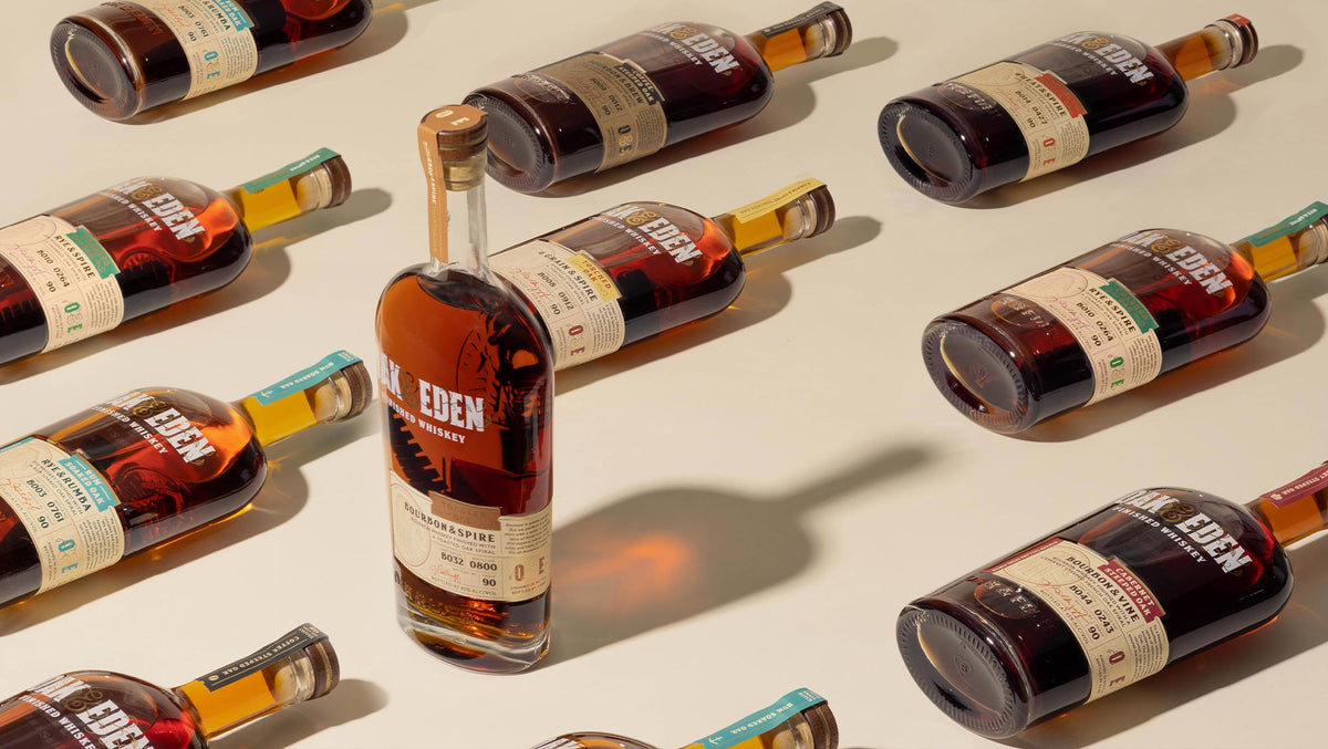 Cream background with a variety of Oak & Eden bottles lying down and one standing up. Featured is Bourbon & Spire, Rye & Rumba and 4 Grain & Spire.
